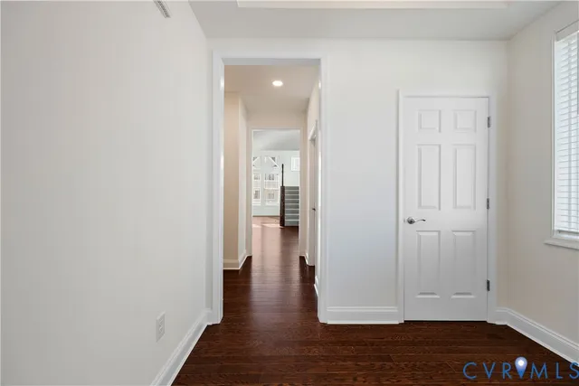 a view of an empty room with wooden floor and closet