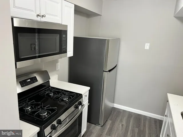 a kitchen with granite countertop a stove and a microwave