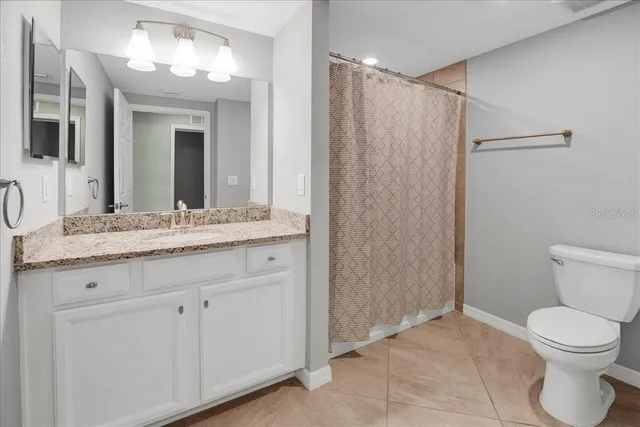 an empty room with chandelier fan