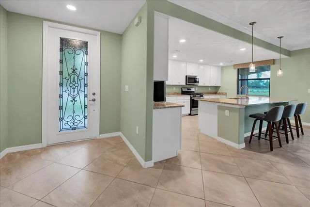 a kitchen with a table chairs refrigerator and microwave