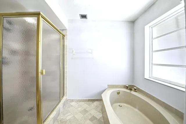 a bathroom with a tub and a window