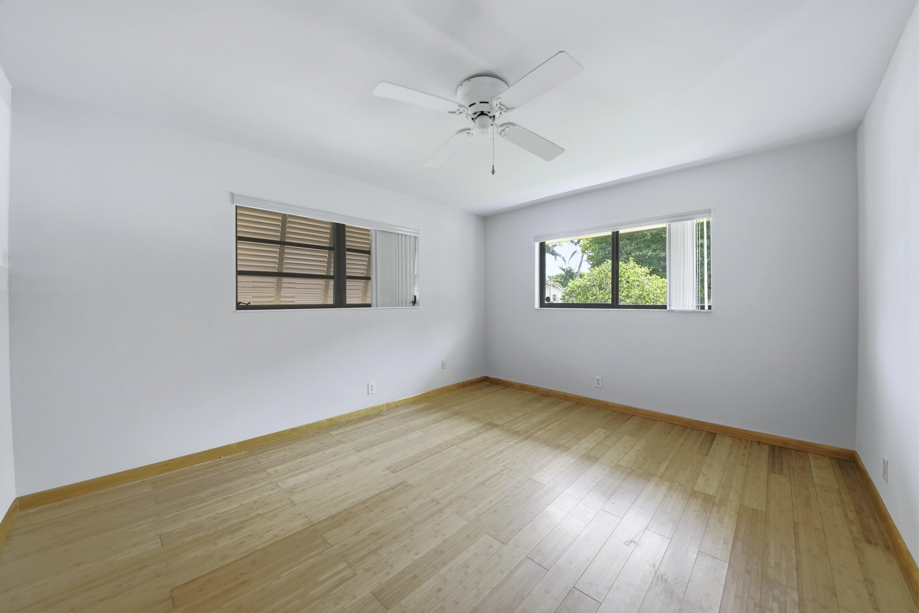 309 Southeast 4th Street Dania Beach, FL 33004 - Photo 16 of 23 an empty room with wooden floor chandelier and windows