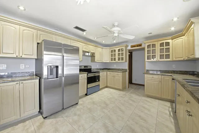 a kitchen with cabinets stainless steel appliances and a window