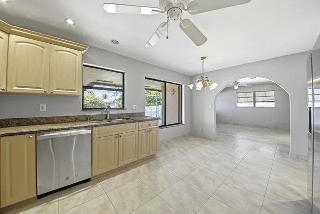 a kitchen with granite countertop a stove a sink and chandelier