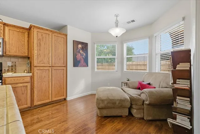 a living room with kitchen island granite countertop furniture and a flat screen tv