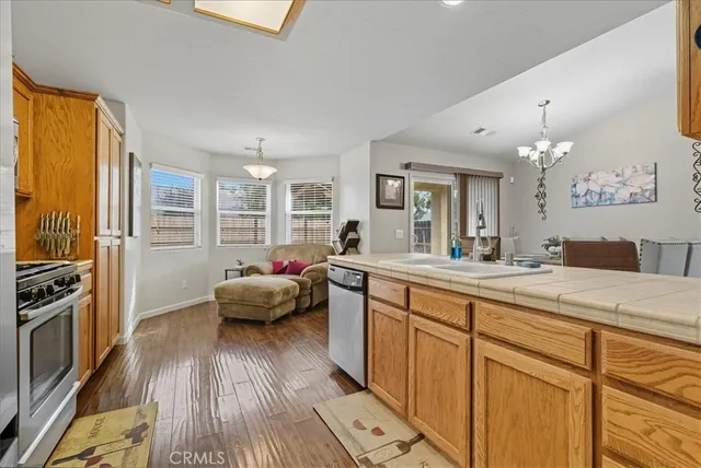 a living room with kitchen island granite countertop wooden floor and stainless steel appliances