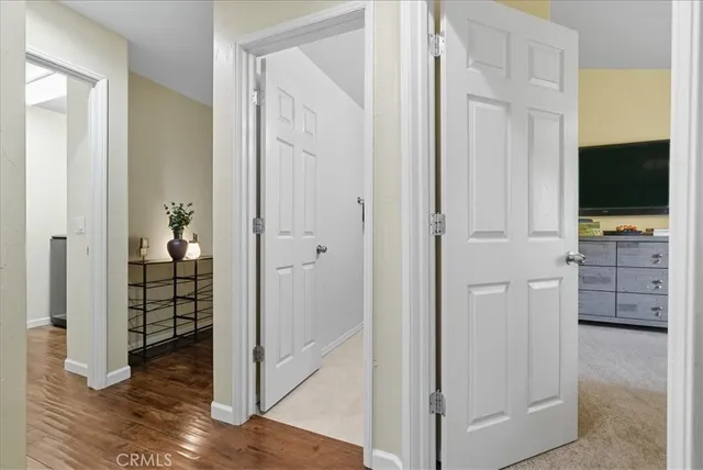 a view of a hallway with wooden floor and closet area