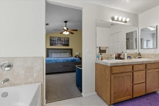 a bathroom with a tub sink and mirror