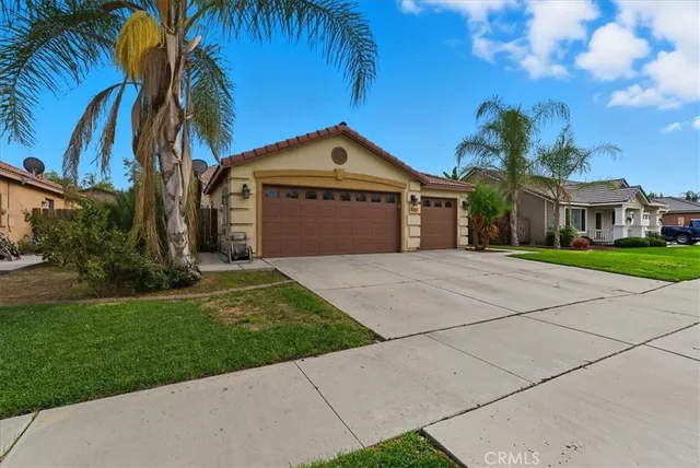 a front view of a house with a garden and trees