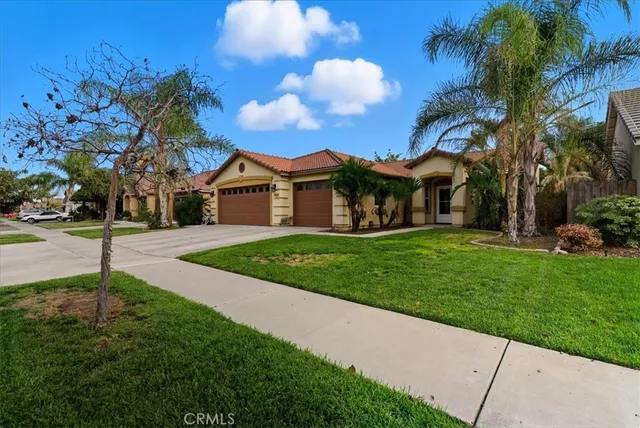 a view of a house with a big yard and palm trees