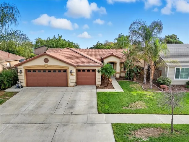 a front view of a house with a yard and potted plants