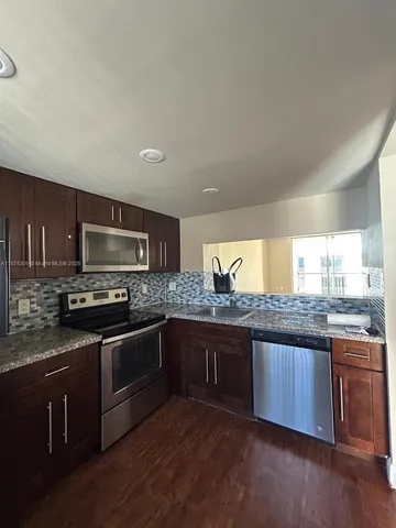 a kitchen with stainless steel appliances granite countertop a sink and stove top oven