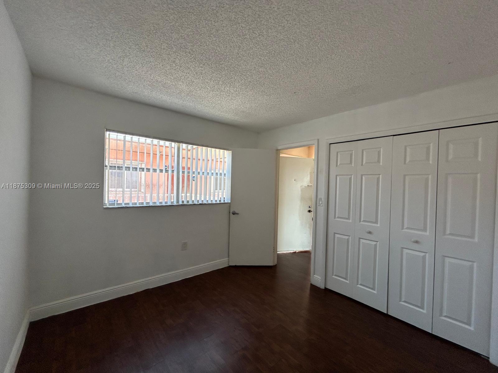 19741 Southwest 114th Avenue, Unit 361 Miami, FL 33157 - Photo 9 of 20 an empty room with wooden floor and windows
