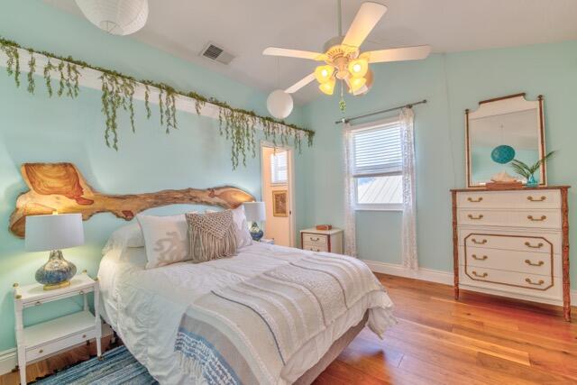 5125 Southeast Matousek Street Stuart, FL 34997 - Photo 20 of 39 a bedroom with a bed and wooden floor