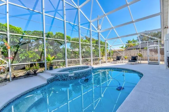 a large swimming pool with a lawn chairs and a yard