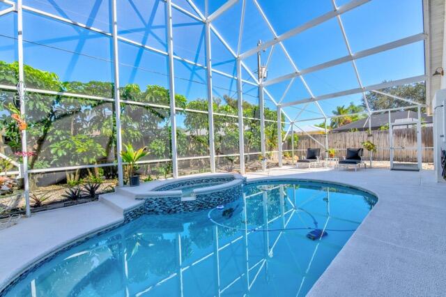 5125 Southeast Matousek Street Stuart, FL 34997 - Photo 27 of 39 a large swimming pool with a lawn chairs and a yard