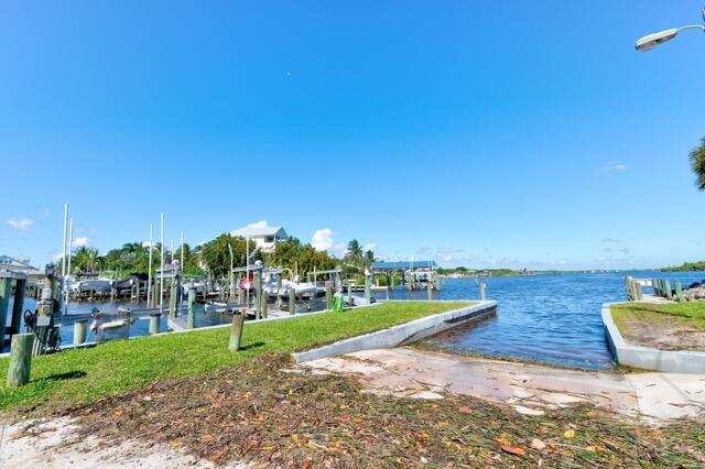 5125 Southeast Matousek Street Stuart, FL 34997 - Photo 31 of 39 a view of a swimming pool with lawn chairs plants and palm trees