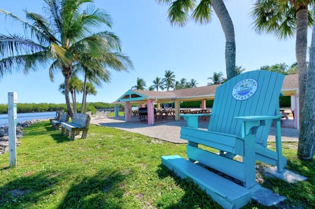 5125 Southeast Matousek Street Stuart, FL 34997 - Photo 33 of 39 a swimming pool with outdoor seating and a garden