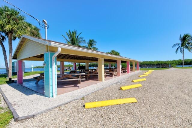 5125 Southeast Matousek Street Stuart, FL 34997 - Photo 36 of 39 a view of a swimming pool with a table and chairs under an umbrella
