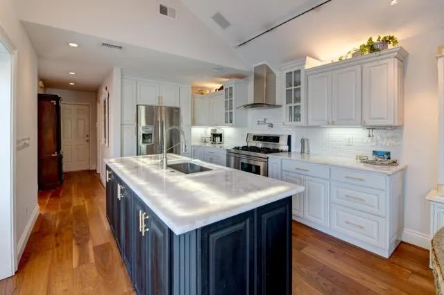 a kitchen with granite countertop a sink stove and cabinets