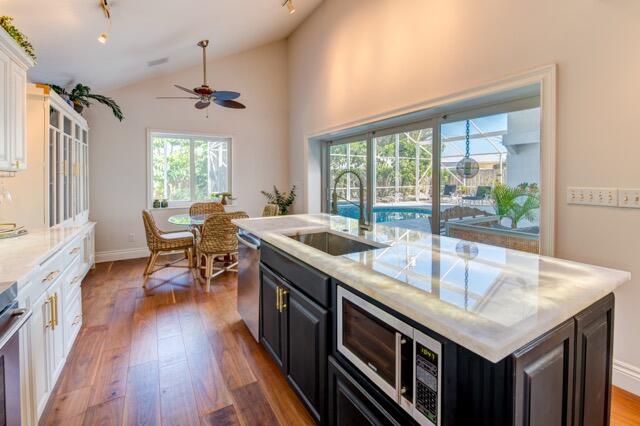 5125 Southeast Matousek Street Stuart, FL 34997 - Photo 7 of 39 a kitchen with stainless steel appliances granite countertop a sink a stove and a wooden floors