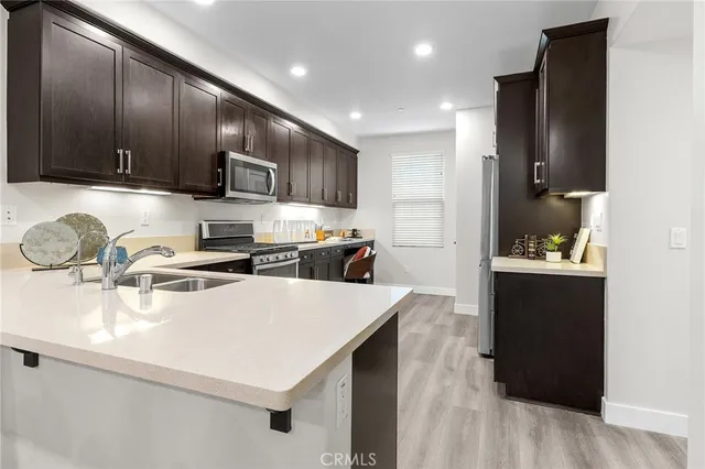 a kitchen with stainless steel appliances a sink a stove a refrigerator and cabinets
