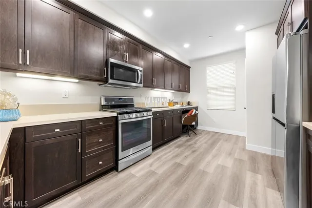 a kitchen with stainless steel appliances granite countertop a refrigerator and a stove top oven