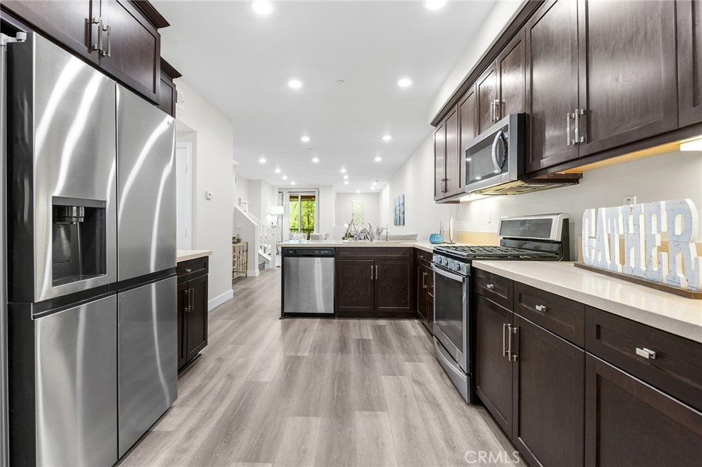 67 Plateau Irvine, CA 92618 - Photo 15 of 32 a kitchen with stainless steel appliances granite countertop refrigerator a sink a stove top oven and wooden floor