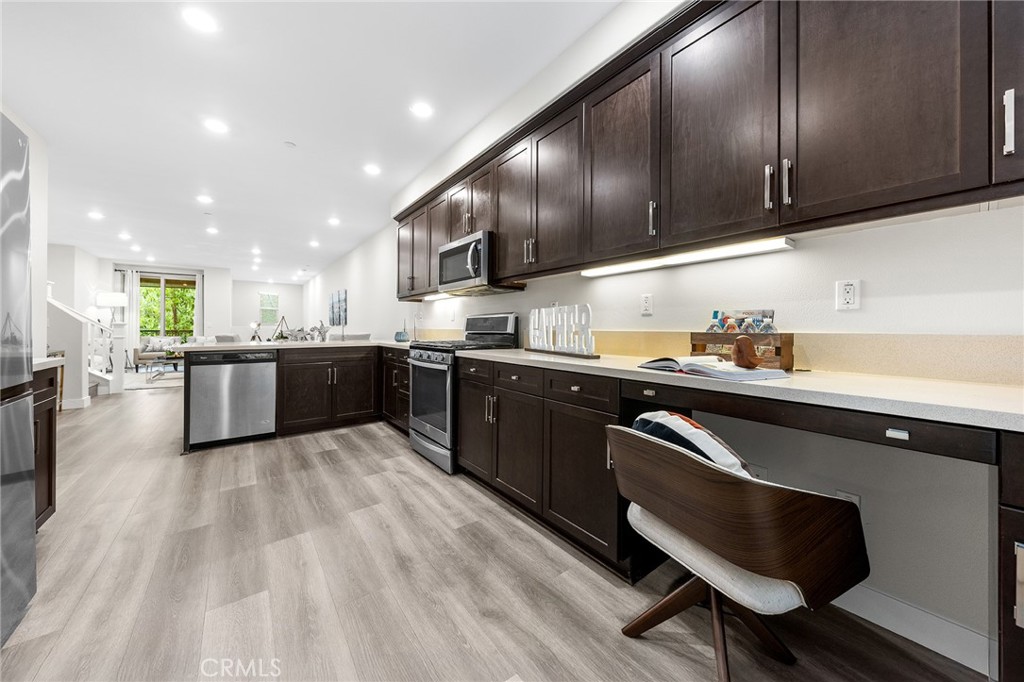 67 Plateau Irvine, CA 92618 - Photo 16 of 32 a kitchen with stainless steel appliances granite countertop wooden cabinets a sink dishwasher a stove and a refrigerator with wooden floor