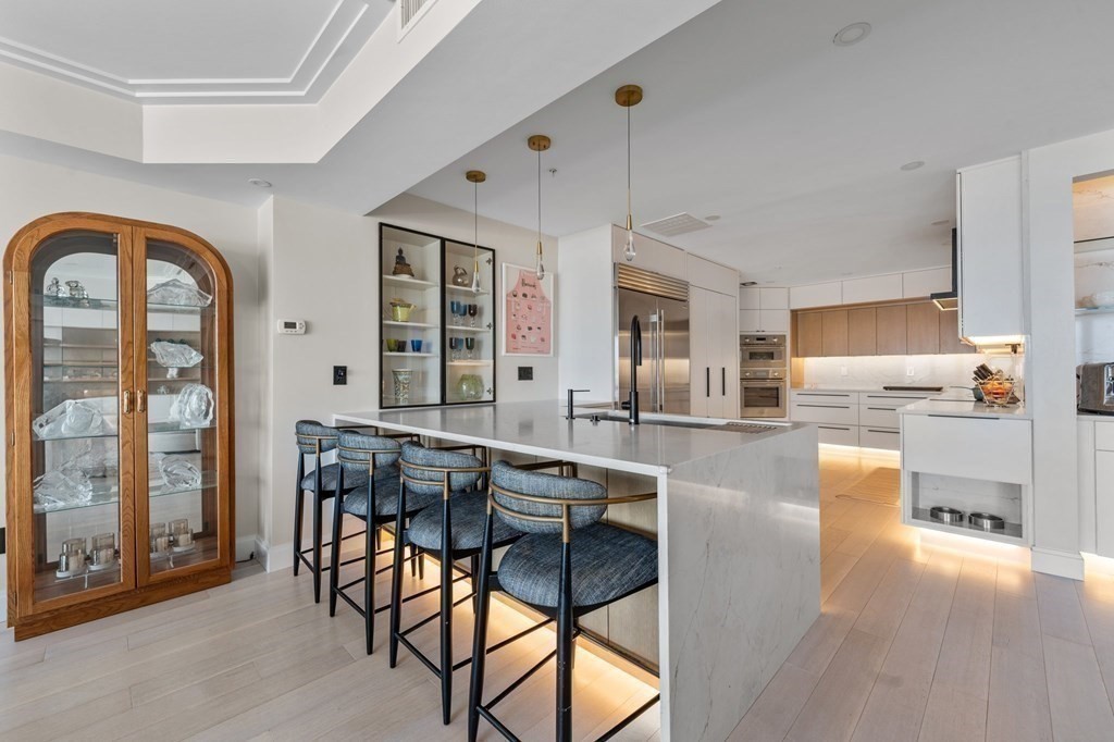 197 8th Street, Unit PH12 Boston, MA 02129 - Photo 18 of 42 a dining hall with stainless steel appliances kitchen island granite countertop a dining table chairs and view living room