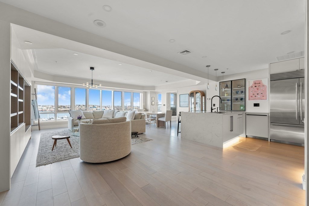 197 8th Street, Unit PH12 Boston, MA 02129 - Photo 7 of 42 a living room with stainless steel appliances kitchen island granite countertop a couch and a view of kitchen