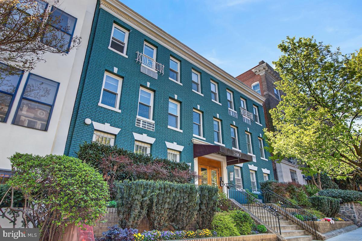 Charming brick facade with lush greenery.