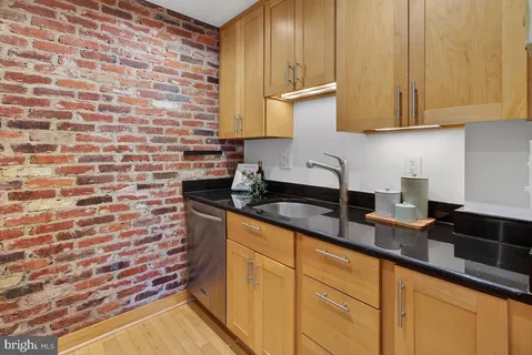 a kitchen with granite countertop white cabinets and stainless steel appliances