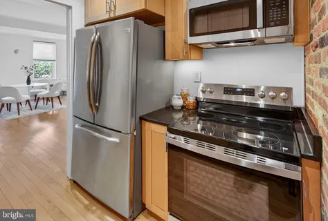 a kitchen with stainless steel appliances granite countertop a refrigerator stove and microwave