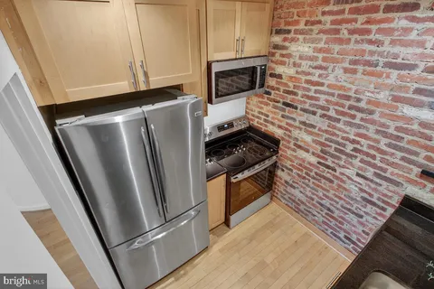 a kitchen with granite countertop a refrigerator stove and microwave