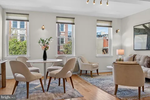 a living room with furniture and a painting on the wall