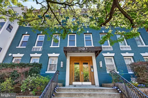 a front view of a residential apartment building with a yard