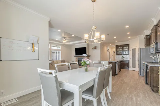 a view of a dining room and livingroom with furniture wooden floor a chandelier