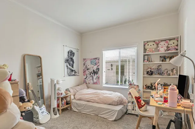 a bedroom with a bed a large window with table and chairs