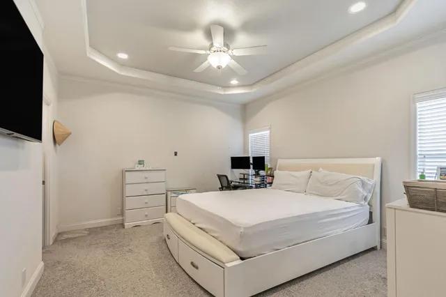 a bedroom with a bed a flat screen tv and a chandelier