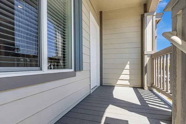 a view of a balcony with wooden floor and fence