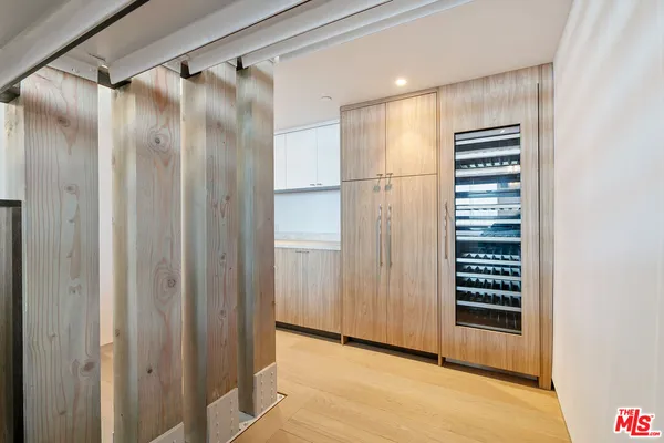 a view of a hallway with wooden floor and a bathroom