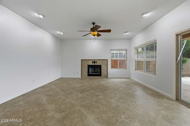 an empty room with a window and a ceiling fan