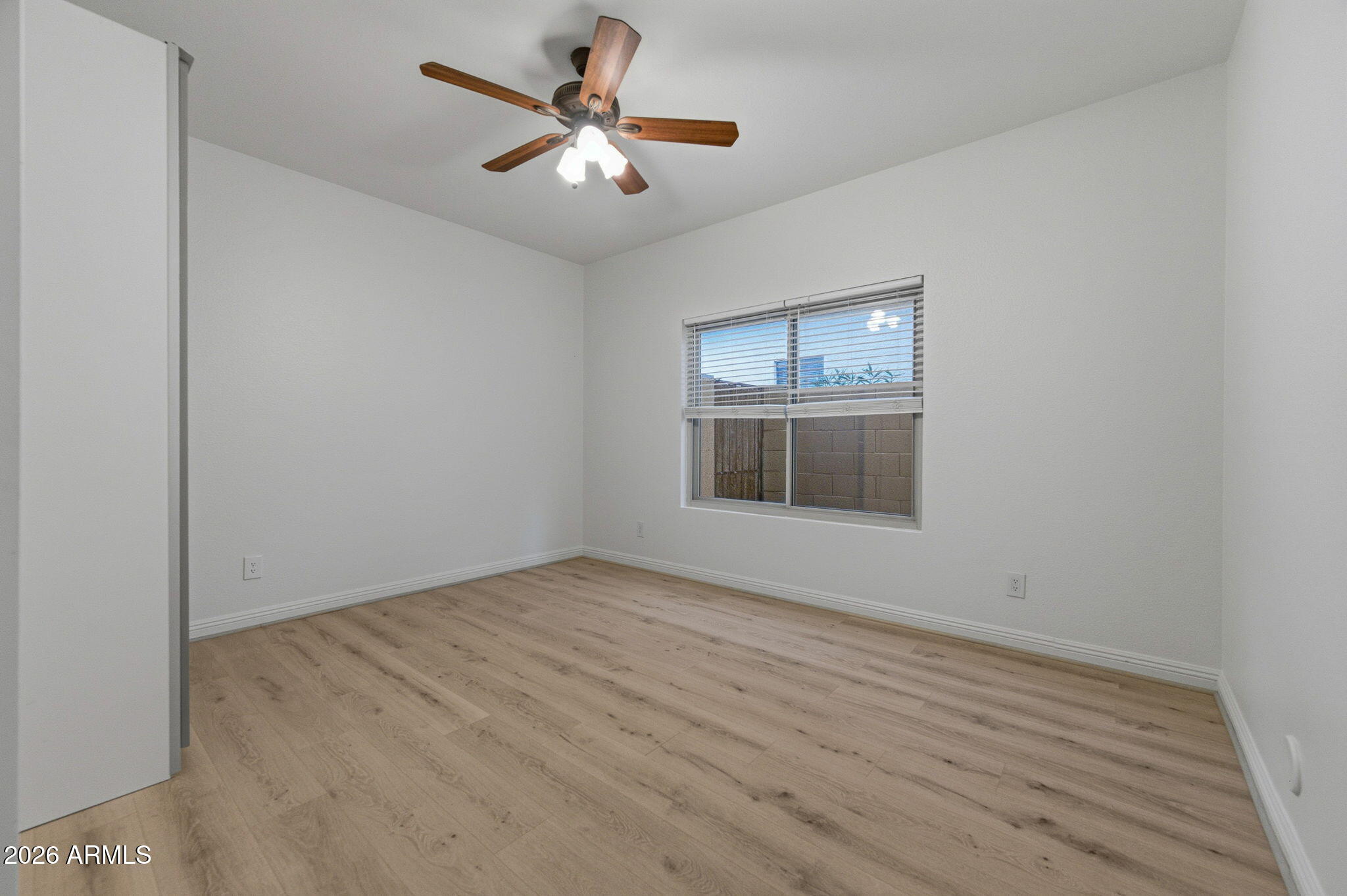 16601 South 15th Street Phoenix, AZ 85048 - Photo 27 of 62 an empty room with wooden floor chandelier fan and windows