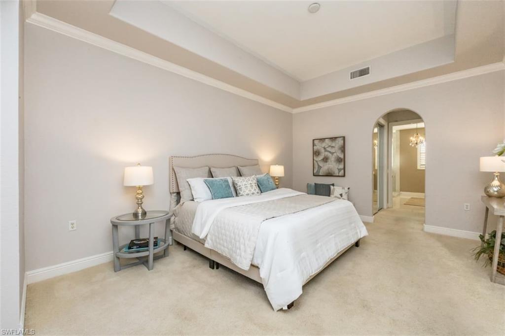 770 Regency Reserve Circle, Unit 1803 Naples, FL 34119 - Photo 14 of 35 a bedroom with a bed and a lamp on table