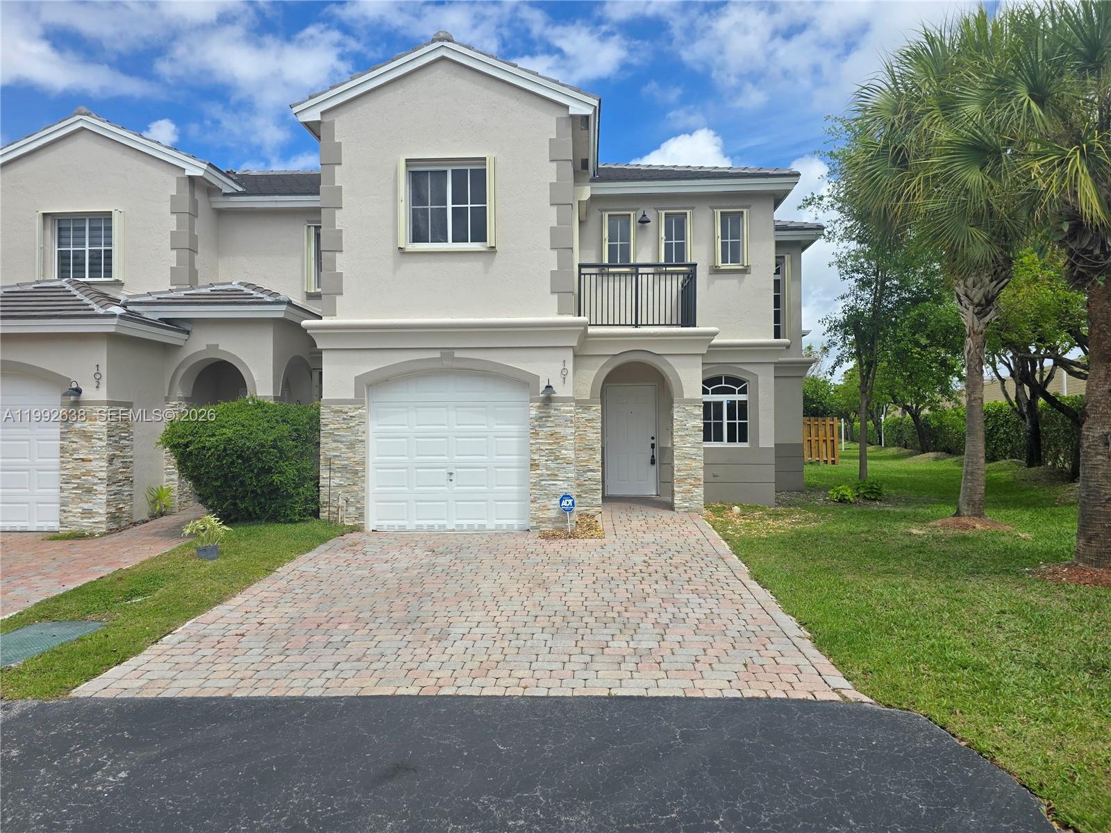 a front view of a house with a yard and garage