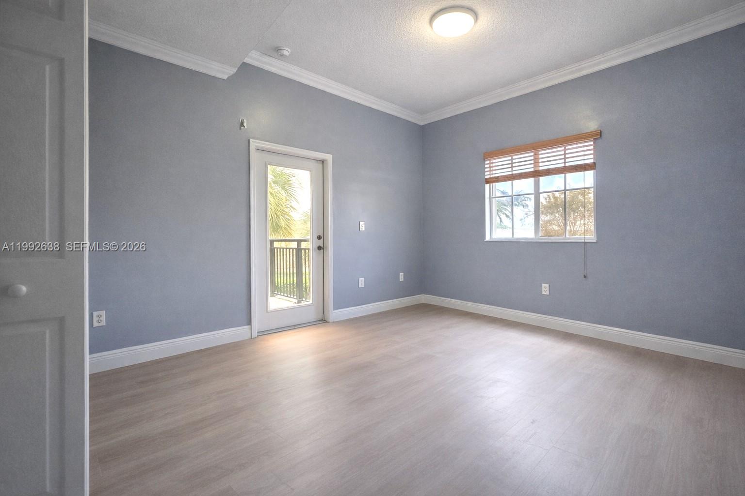 8421 Southwest 124th Avenue, Unit 101 Miami, FL 33183 - Photo 13 of 20 an empty room with wooden floor and windows