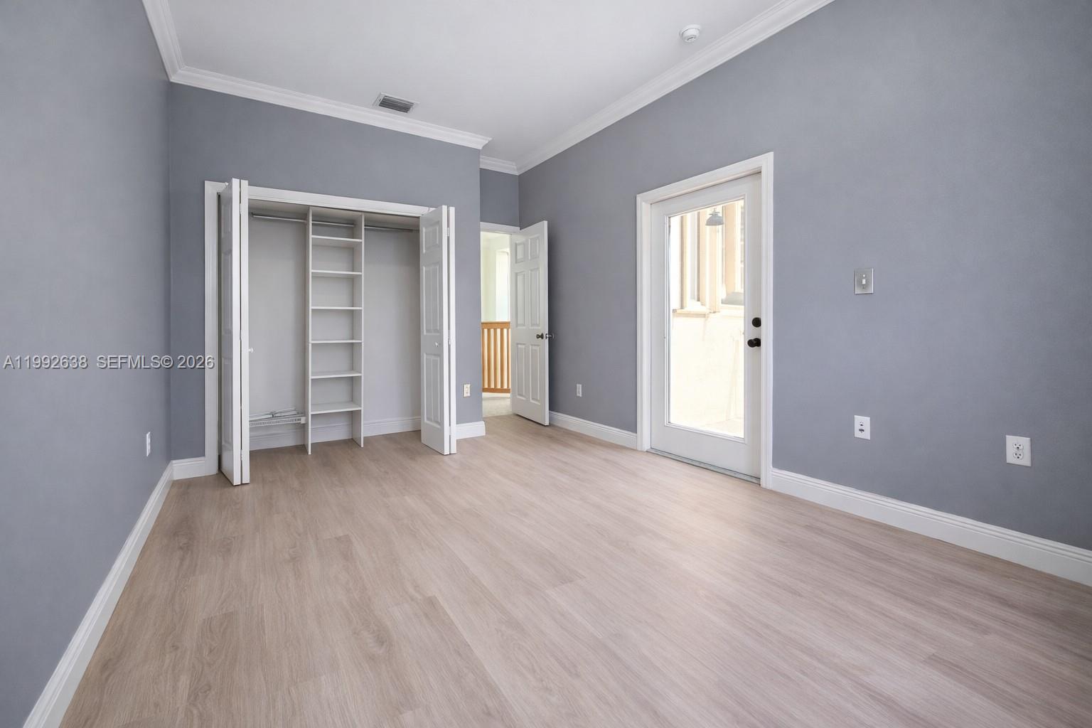 8421 Southwest 124th Avenue, Unit 101 Miami, FL 33183 - Photo 14 of 20 a view of an empty room with wooden floor and closet