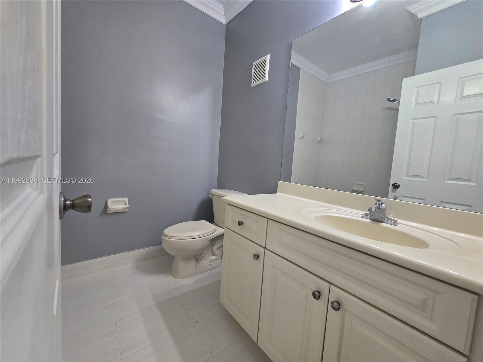 8421 Southwest 124th Avenue, Unit 101 Miami, FL 33183 - Photo 15 of 20 a bathroom with a granite countertop toilet and a sink