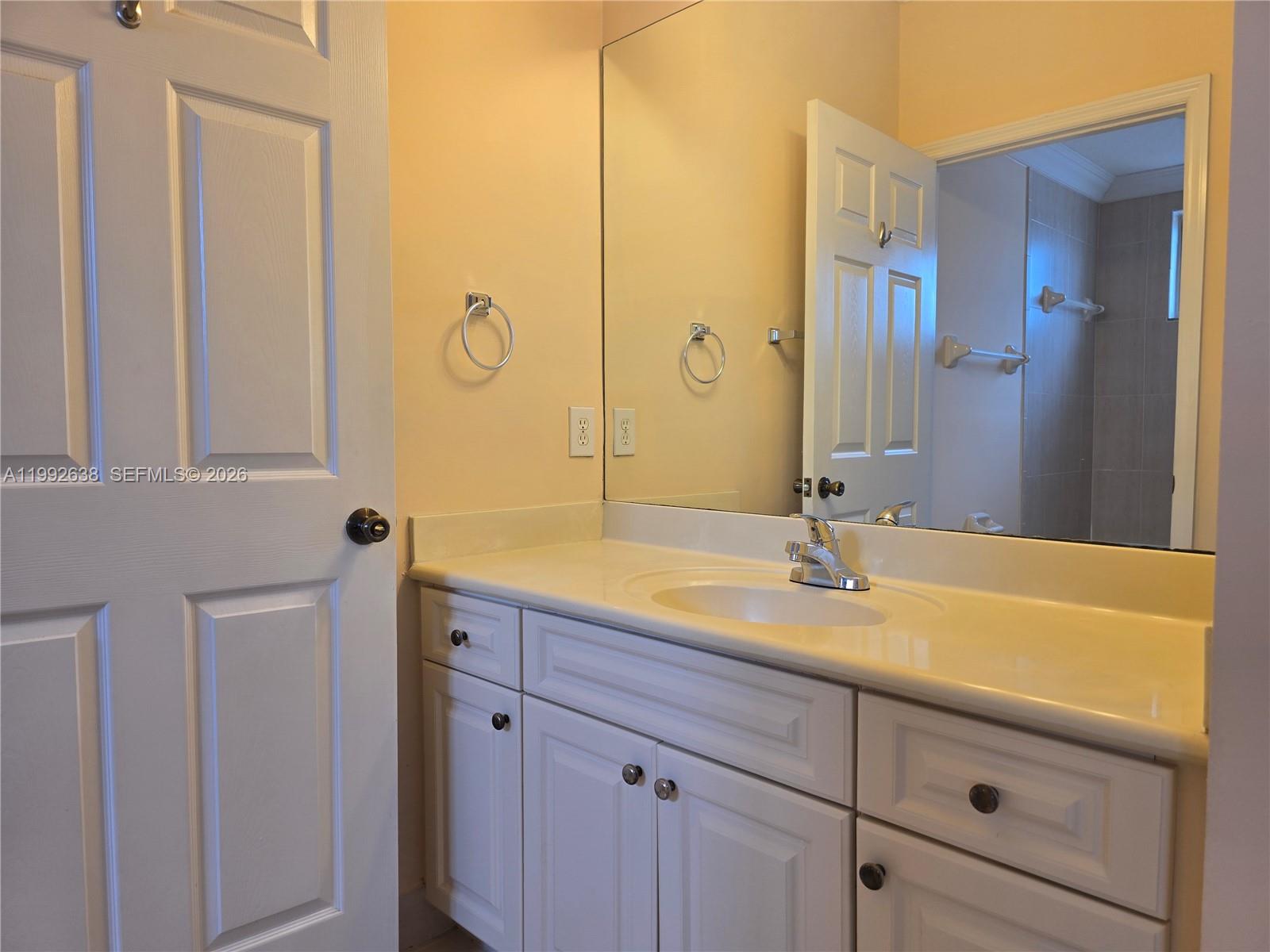 8421 Southwest 124th Avenue, Unit 101 Miami, FL 33183 - Photo 16 of 20 a bathroom with a granite countertop sink and a mirror